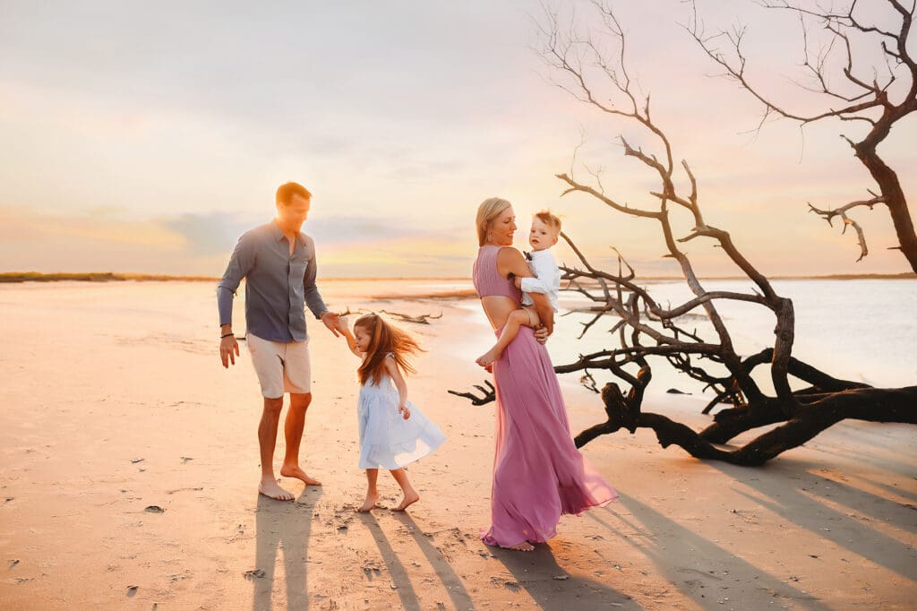 Parents dance with their children in the sunset on Folly Beach during Family Photos with Holy City Family Photography.
