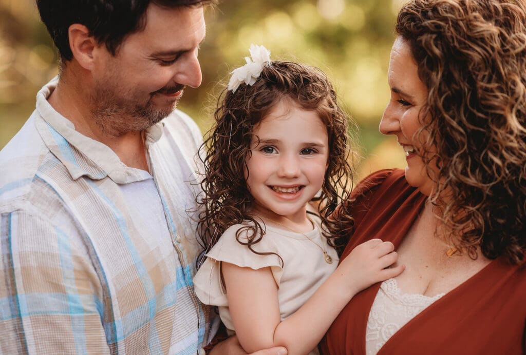 Parents embrace their daughter during Family Portraits on Kiawah Island with Holy City Family Photography after discovering the blog post about Things to Do on Kiawah Island with Kids.