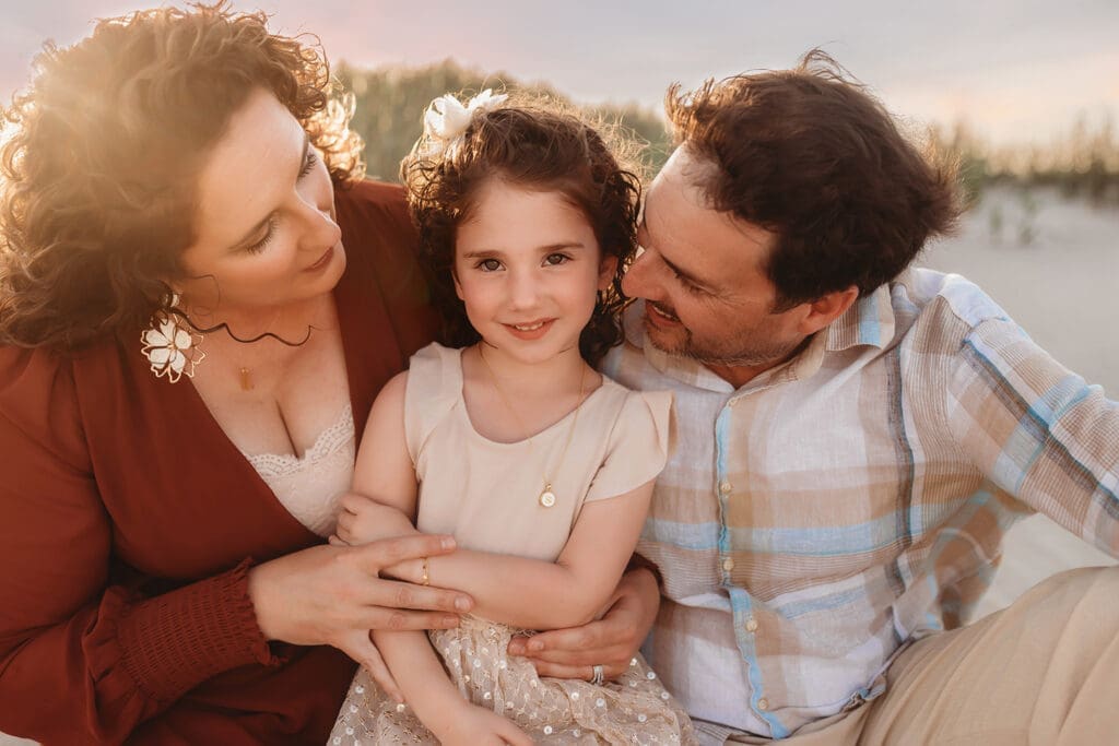 Parents embrace their daughter during Family Photoshoot on Kiawah Island with Holy City Family Photography after discovering the blog post about Things to Do on Kiawah Island with Kids.