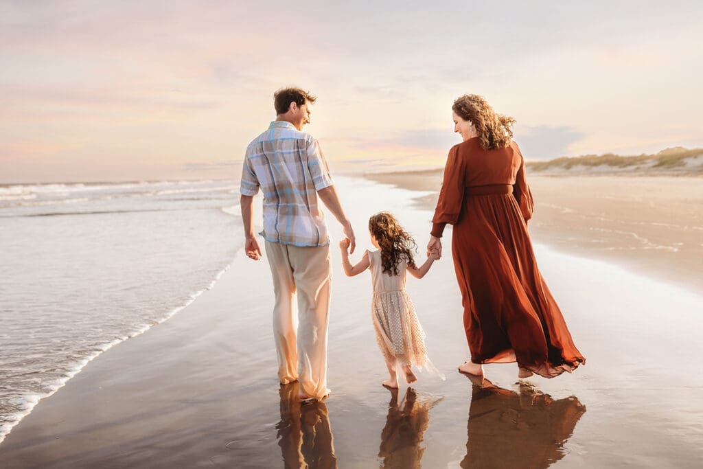 Parents walk along the beach with their daughter during Family Photos on Kiawah Island with Holy City Family Photography after discovering the blog post about Things to Do on Kiawah Island with Kids.