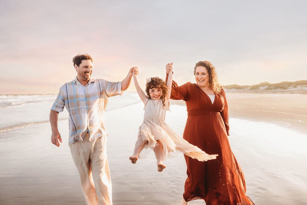 Parents play with their daughter during Family Photoshoot on Kiawah Island with Holy City Family Photography after discovering the blog post about Things to Do on Kiawah Island with Kids.