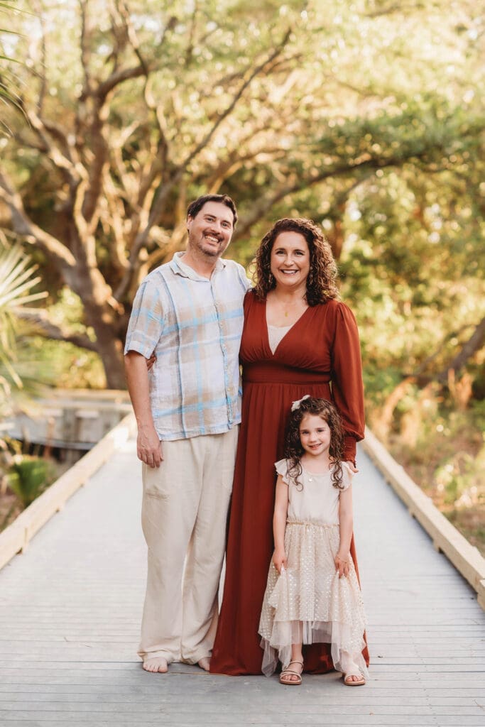 Parents embrace their daughter during Family Portraits on Kiawah Island with Holy City Family Photography after discovering the blog post about Things to Do on Kiawah Island with Kids.
