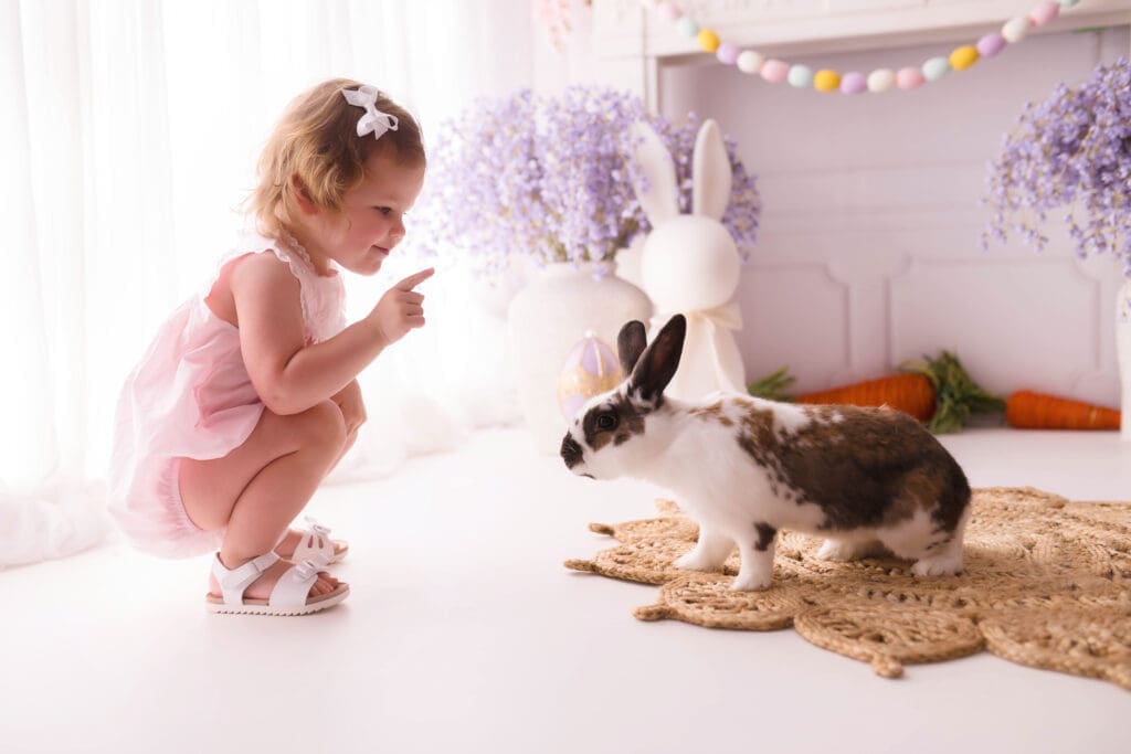 Little girl interacts with a live bunny during Easter Mini Sessions in Charleston, SC. 
