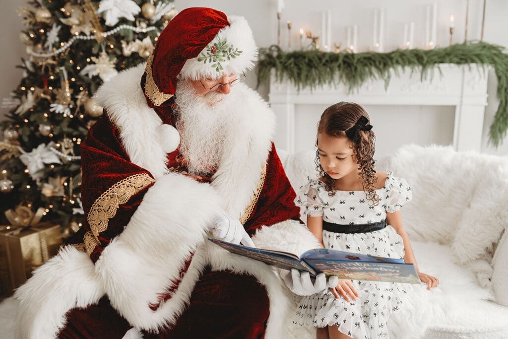 Santa reads to a little girl during Santa Mini Sessions in Charleston, SC. 