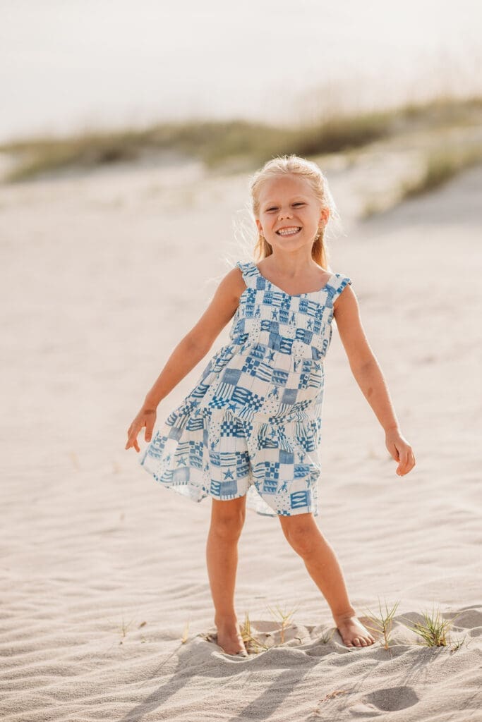 Child smiles at the camera on Isle of Palms Beach during Family Portrait Session with Isle of Palms Beach Photographer, Holy City Family Photography in Charleston, SC.