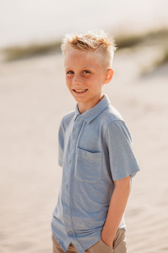 Child smiles at the camera on Isle of Palms Beach during Family Portrait Session with Isle of Palms Beach Photographer, Holy City Family Photography in Charleston, SC.