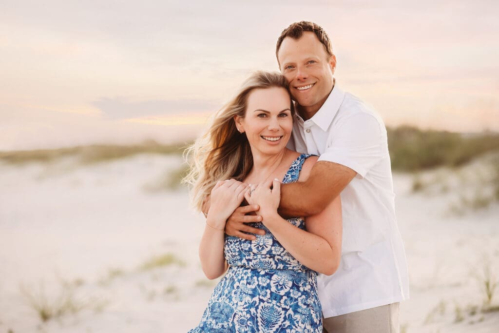 Couple poses together on Isle of Palms Beach during Family Portrait Session with Isle of Palms Beach Photographer, Holy City Family Photography in Charleston, SC.