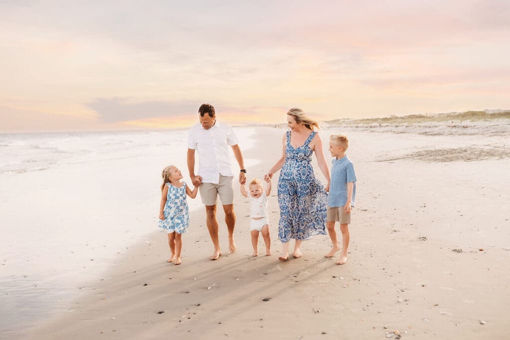 Family walks along the beach together on Isle of Palms Beach during Family Portrait Session with Isle of Palms Beach Photographer, Holy City Family Photography in Charleston, SC.