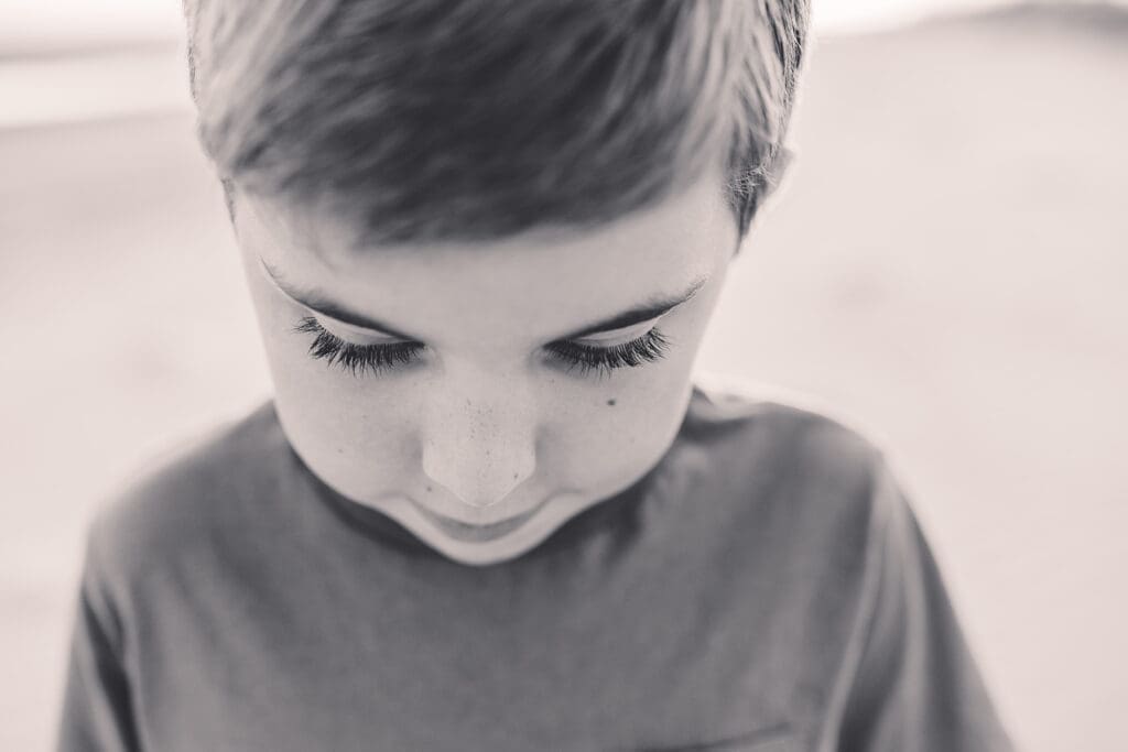 Little boy gazes down, allowing the photographer to capture a macro detail shot of his long eye lashes  during Family Portraits on Kiawah Island with Holy City Family Photography. 
